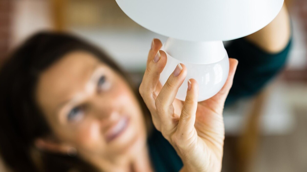 Vrouw draait lamp in